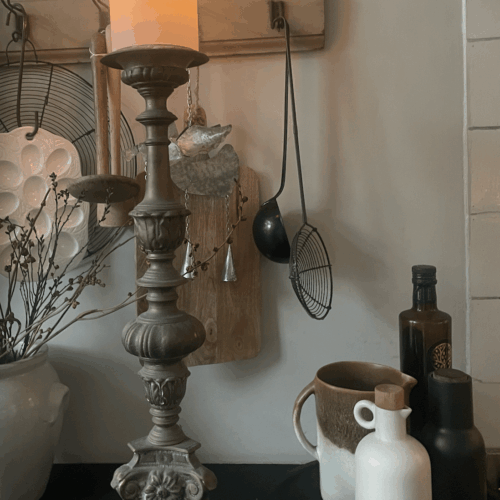 Antieke kerkelijke kandelaar met indrukwekkende details, een echte blikvanger voor een klassiek of rustiek interieur. Deze zware metalen kandelaar staat stevig op drie sierlijke pootjes en is versierd met florale motieven en een majestueuze leeuwenkop. Het bovenste gedeelte biedt ruimte voor een grote kaars, wat zorgt voor een warme, authentieke sfeer. Perfect als decoratiestuk of functioneel item in een sfeervolle woonruimte.
